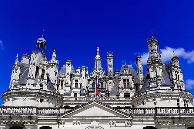 The roofline of Château de Chambord with its towers, lanterns and chimneys against a deep blue sky