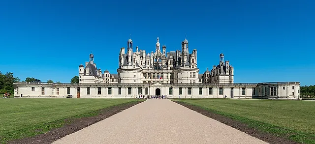 The south-east front of Château de Chambord at the end of a gravel avenue